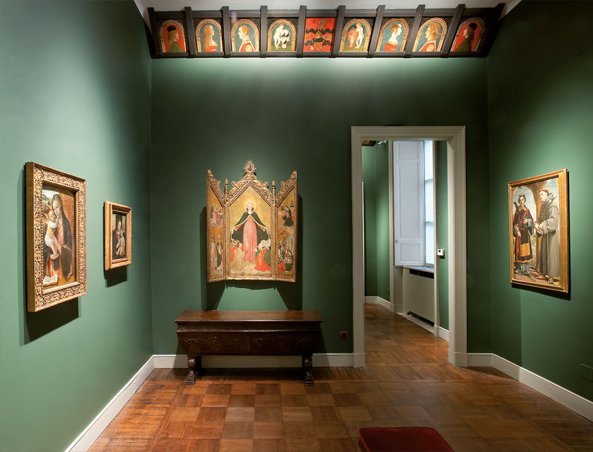 la sala dei lombardi di colore verde con quadri appesi alle pareti su intricati telai dorati e una serie di ritratti sul bordo del soffitto.