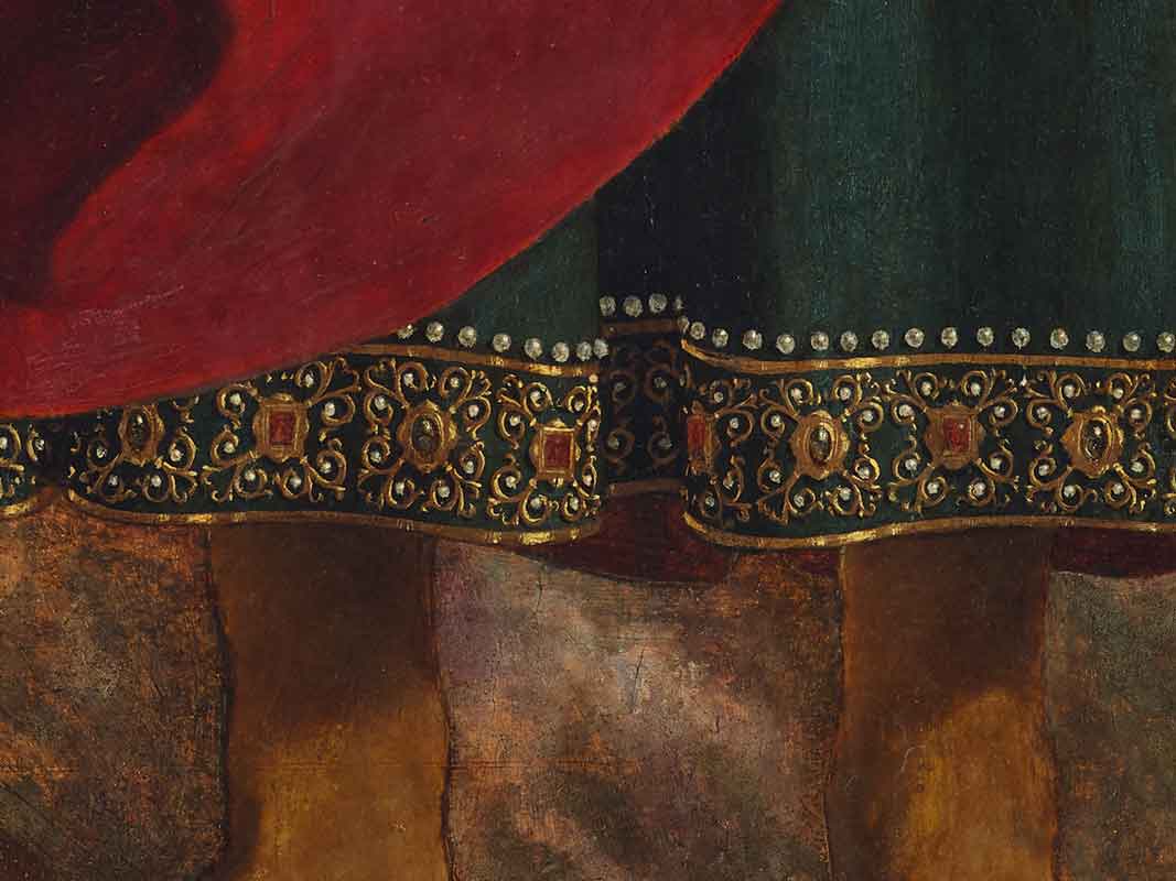 Dettaglio del dipinto di San Giovanni Evangelista di Piero della Francesca che mostra una veste verde scuro e mantello rosso con bordi decorati e motivi dorati. 