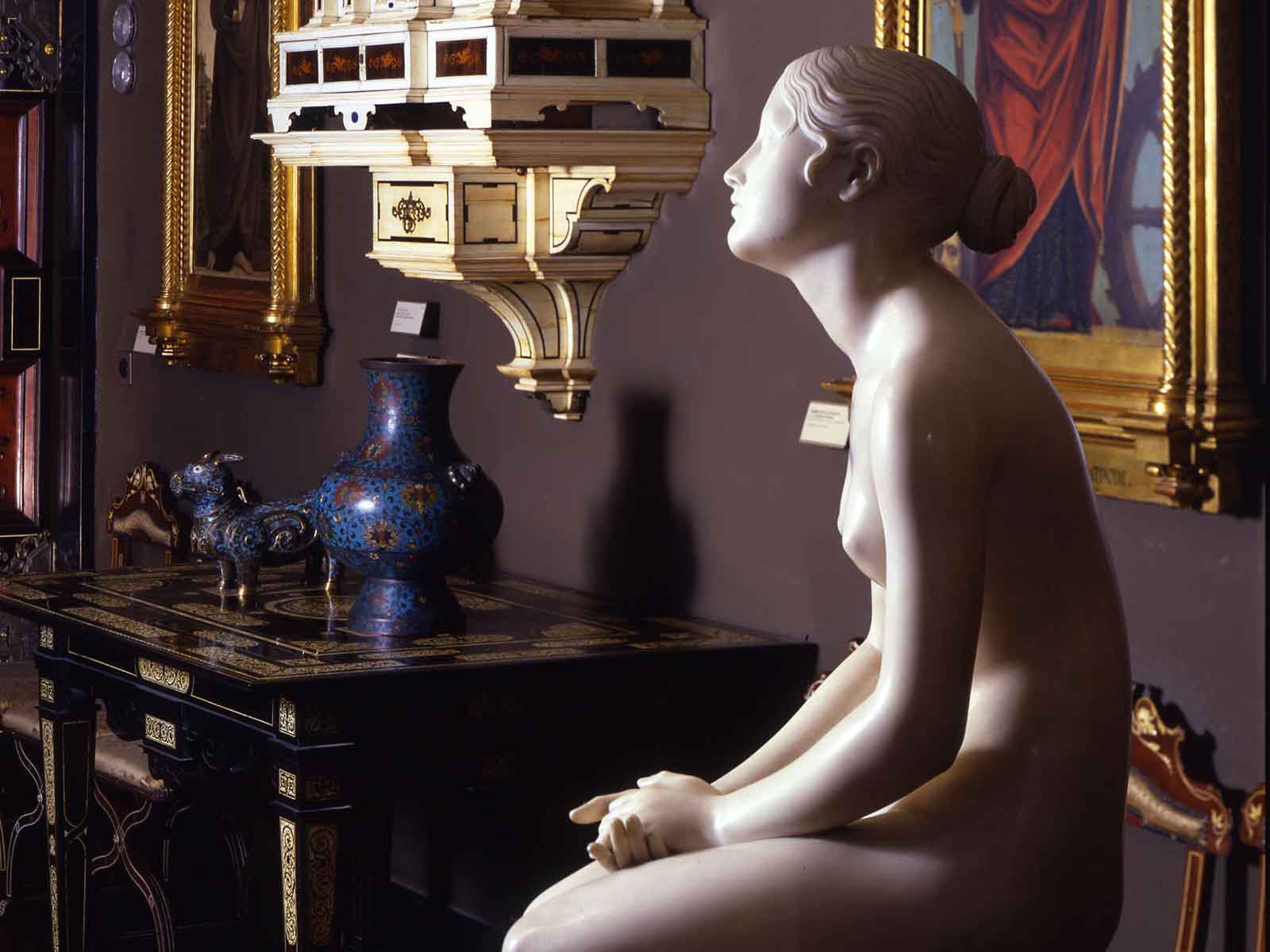 Scultura nella Sala Nera del Museo Poldi Pezzoli di una figura femminile seduta.