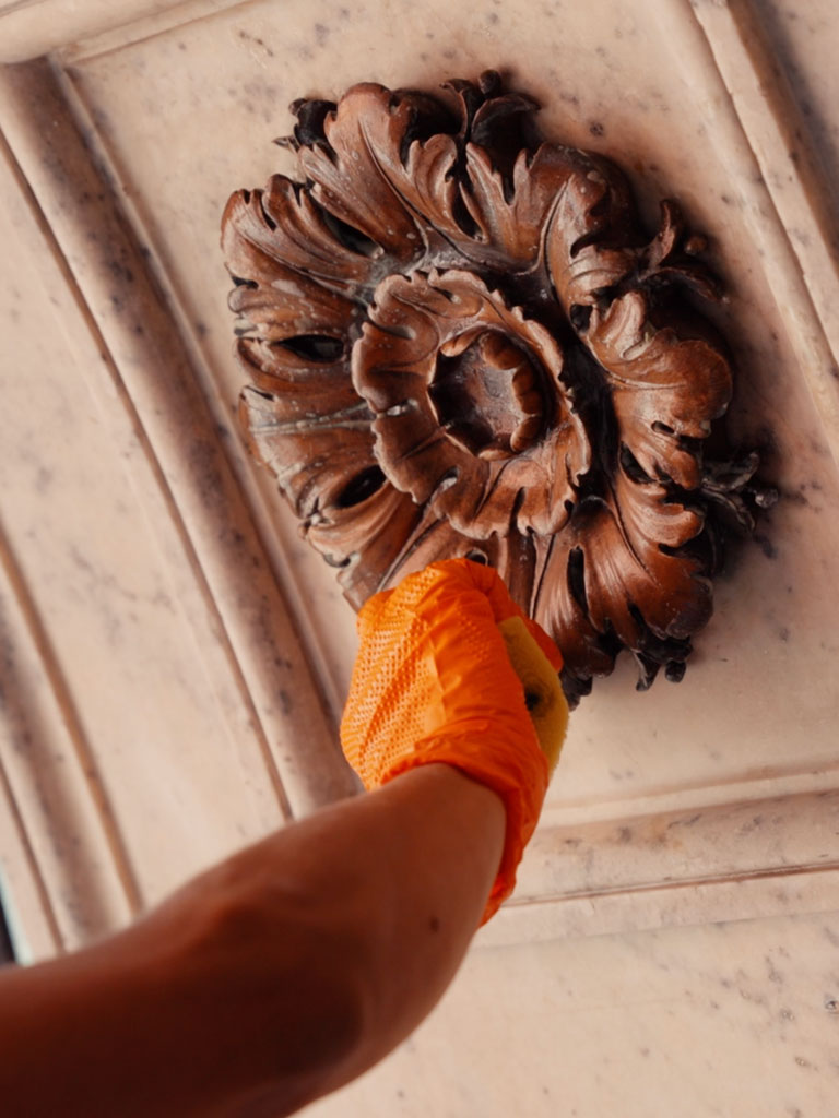 Pulitura di una rosetta in lega Christofle sul basamento della serliana, per rimuovere i depositi accumulati sotto il controsoffitto.