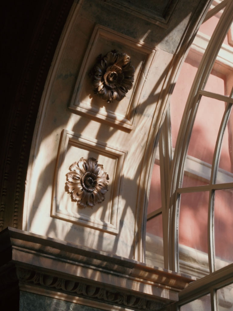 Le rosette bronzee dell'archivolto, in controluce, dopo la rimozione del controsoffitto che le teneva nascoste.
