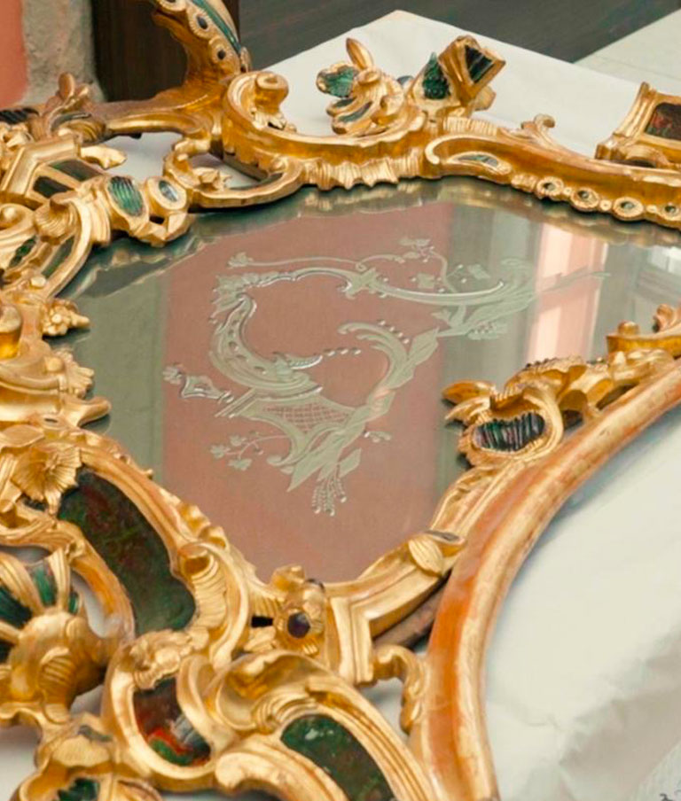 La lastra centrale della specchiera, con una decorazione a motivo vegetale incisa sul vetro, un dettaglio che il restauro riporta in piena luce