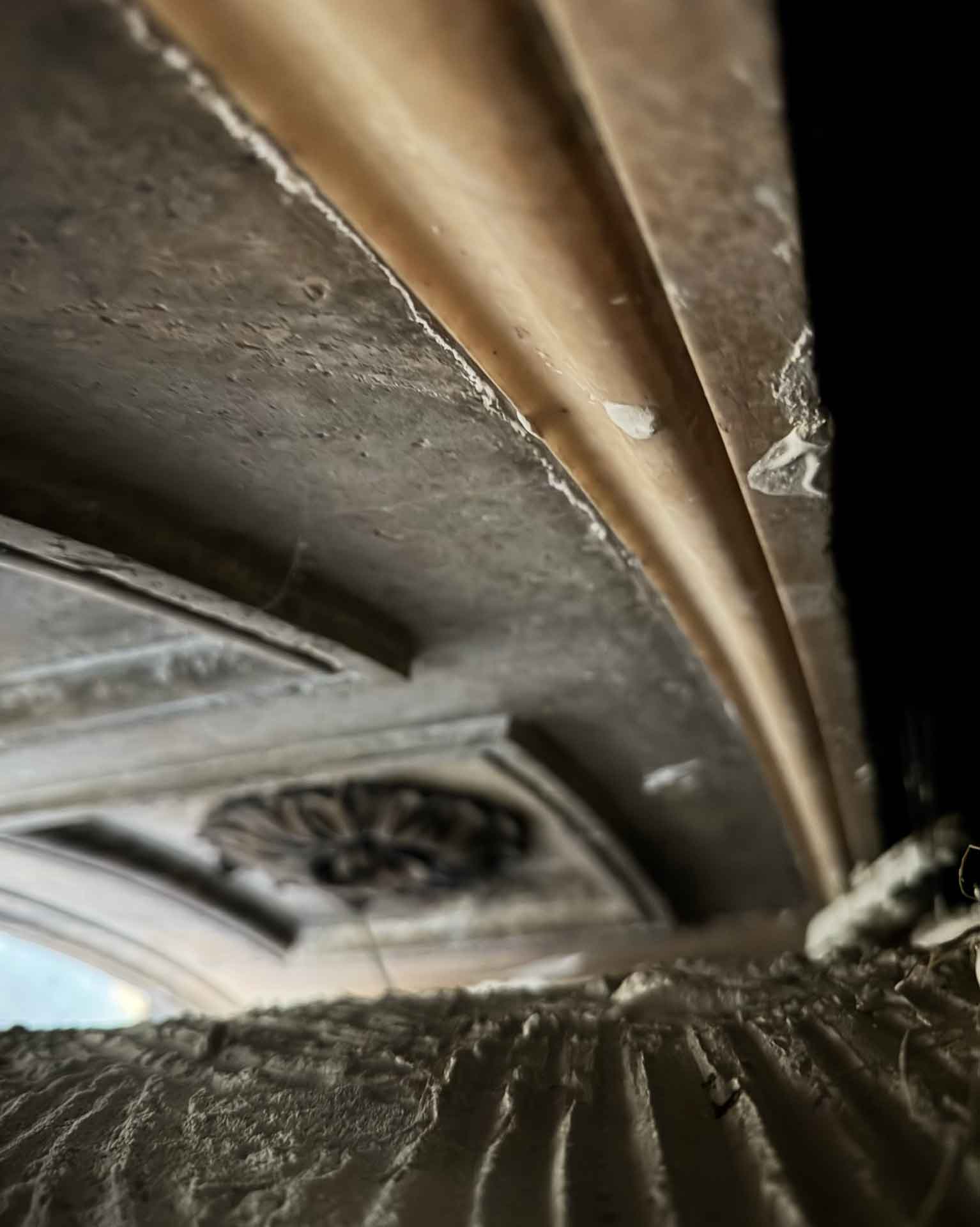 Milano, 2025. Dettaglio ravvicinato dell'intradosso dietro il controsoffitto, durante l'ispezione che ha rivelato le decorazioni ottocentesche rimaste intatte per cinquant'anni