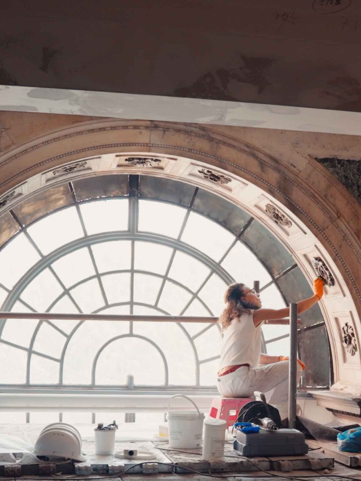 Licia Brescia, restauratrice specializzata in materiale lapideo, al lavoro sull'archivolto della serliana, tra le formelle decorate e i marmi policromi ancora da pulire